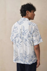 Close-up of blue leaf embroidery pattern on white cotton camp shirt