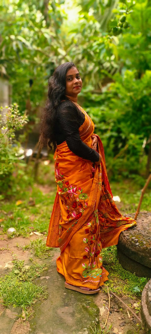 Close-up of lotus embroidery on Swarnalata mustard orange silk saree